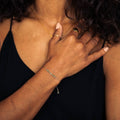 Woman with hand on chest wearing a black top