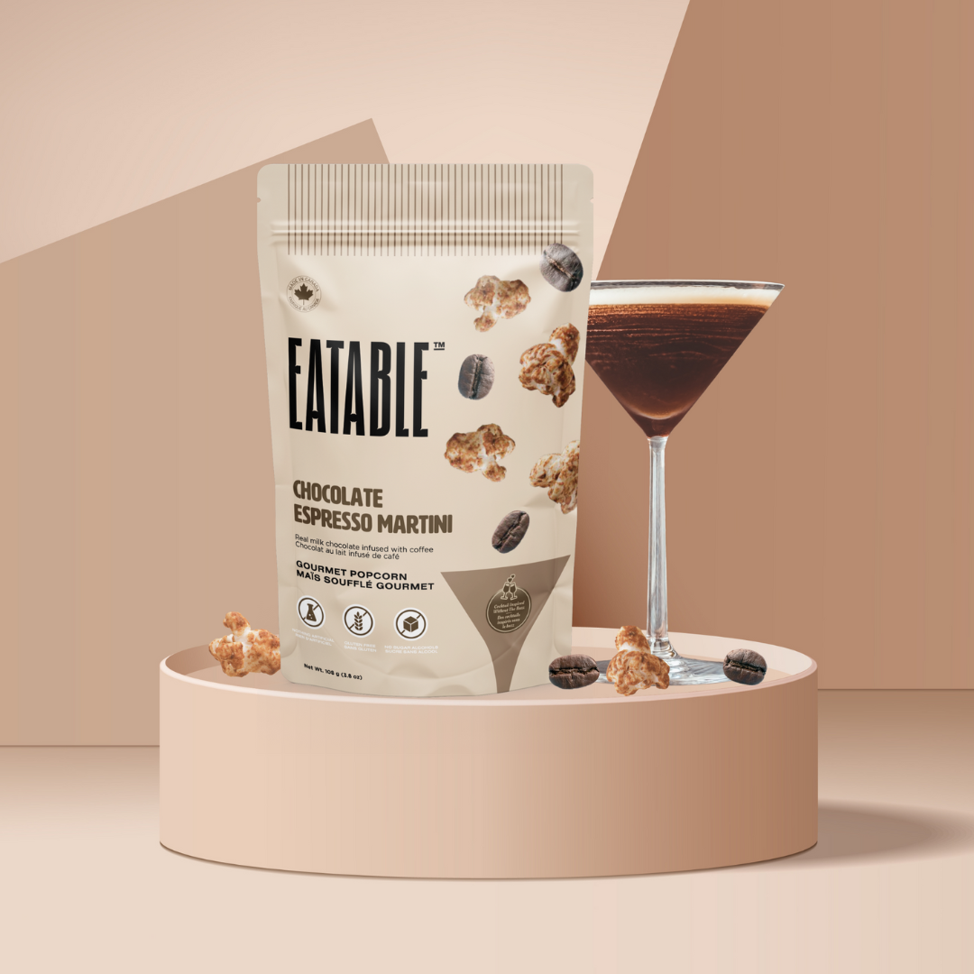 Eatable chocolate espresso martini packaging with a glass of the drink on a beige platform.