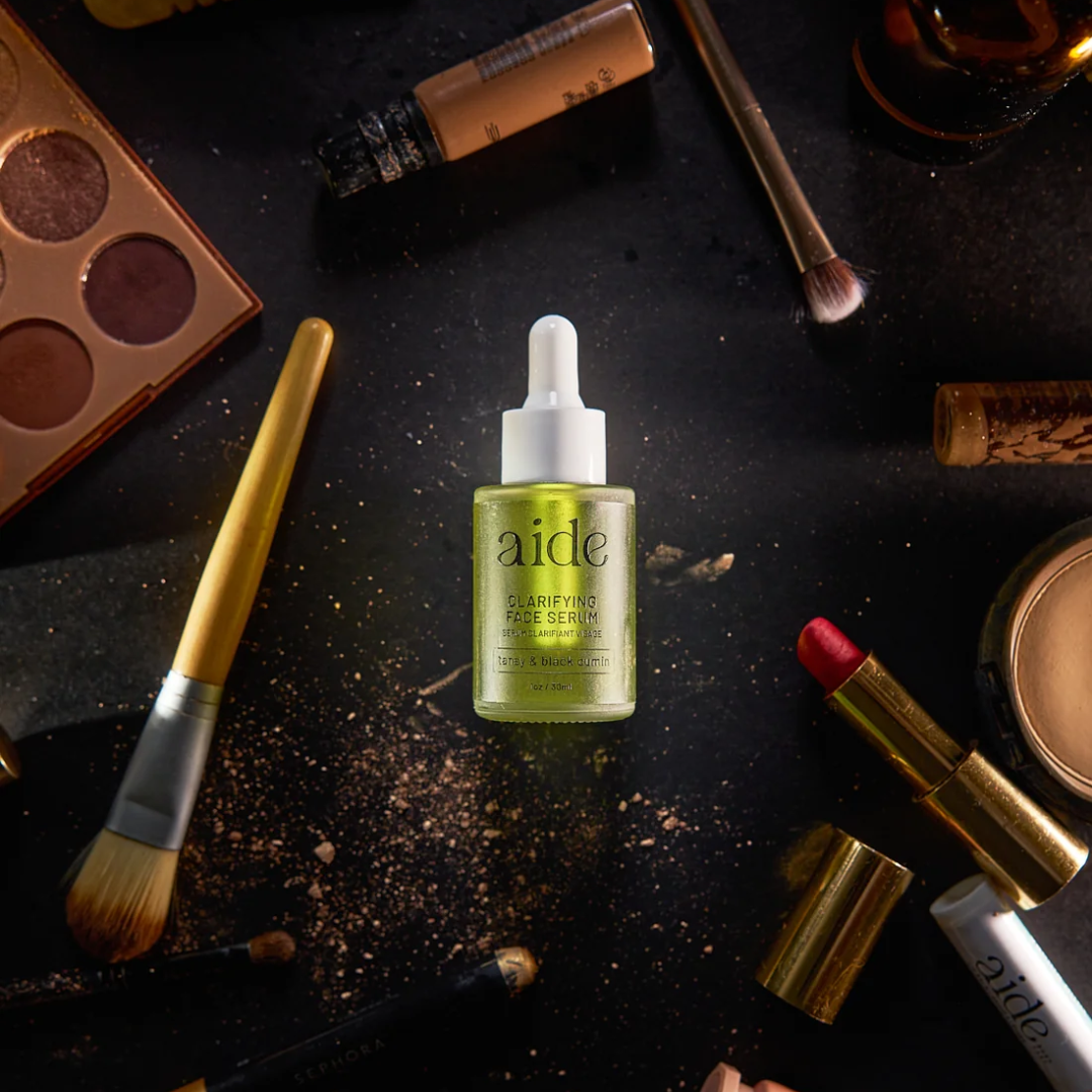 Aide Bodycare Clarifying Face Serum, featuring a small glass bottle with a dropper and a label with 'aide' logo, 'Clarifying Face Serum', and 'tansy & black cumin' text, displayed on a light-colored surface with a soft shadow. The serum is natural and available in Ottawa, Ontario, Canada.