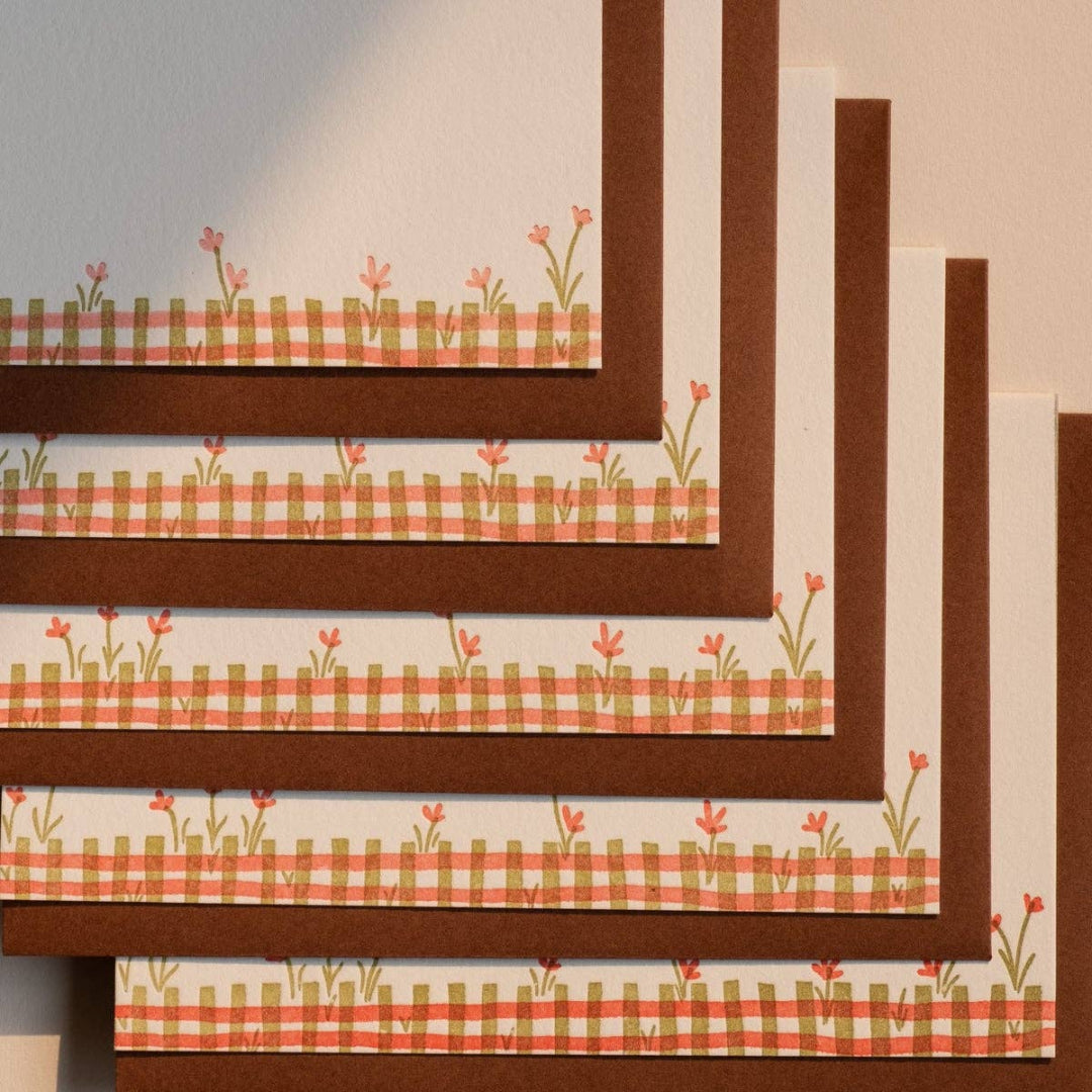 Set of placemats with checkered and floral patterns on a neutral background