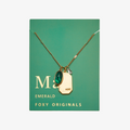 A gold necklace with an emerald stone pendant. The pendant also has the word "HOPE" engraved on it. The necklace is displayed on a green card with the month "May" and the brand name "Foxy Originals."