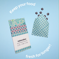 An image of the Beeswax Wrap Variety Set and one being used in an envelope style to store blueberries, with the text "keep your food fresh for longer".