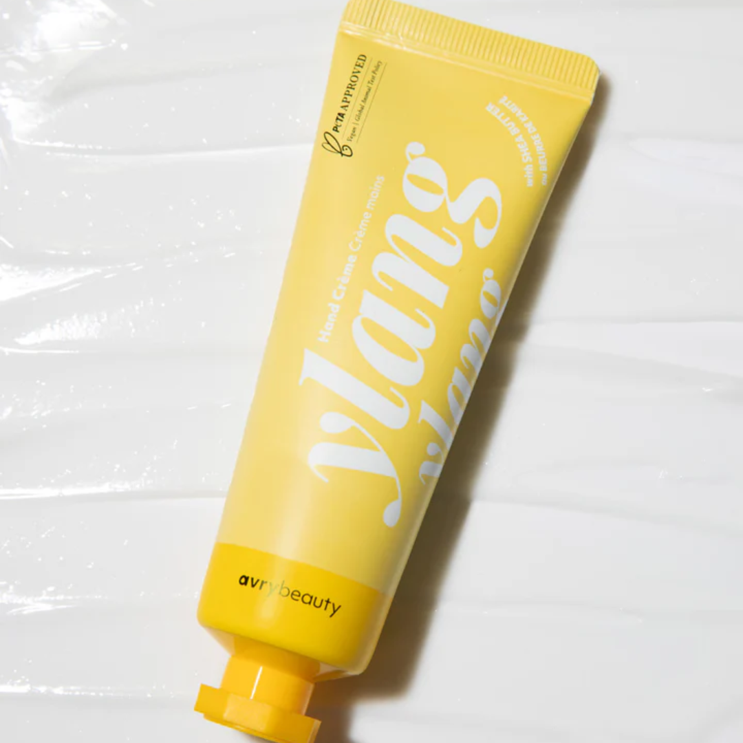 A tube of Ylang Ylang Shea Butter Lotion laying on a smearing of lotion.