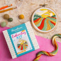 Embroidery kit with colorful fabric design on a textured surface