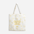 A white tote bag with a yellow smiley face design. The text "It's never too late to have the time of your life" is printed in yellow on the bag, surrounded by smiley faces. The "Epic Blend" logo is also printed in yellow on the bag.