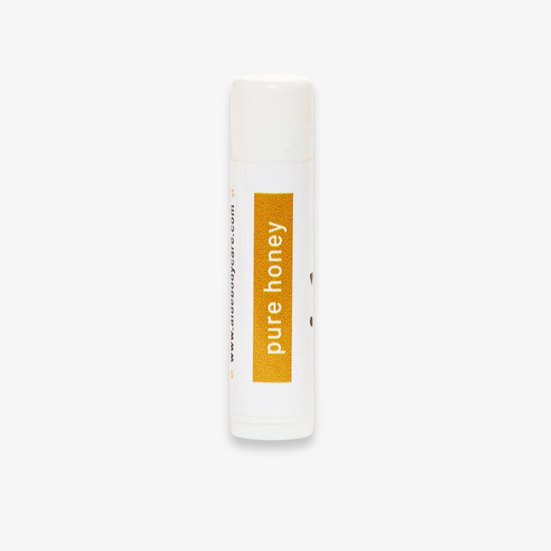 A white tube of lip balm with the word "pure honey" printed in yellow on the label.
