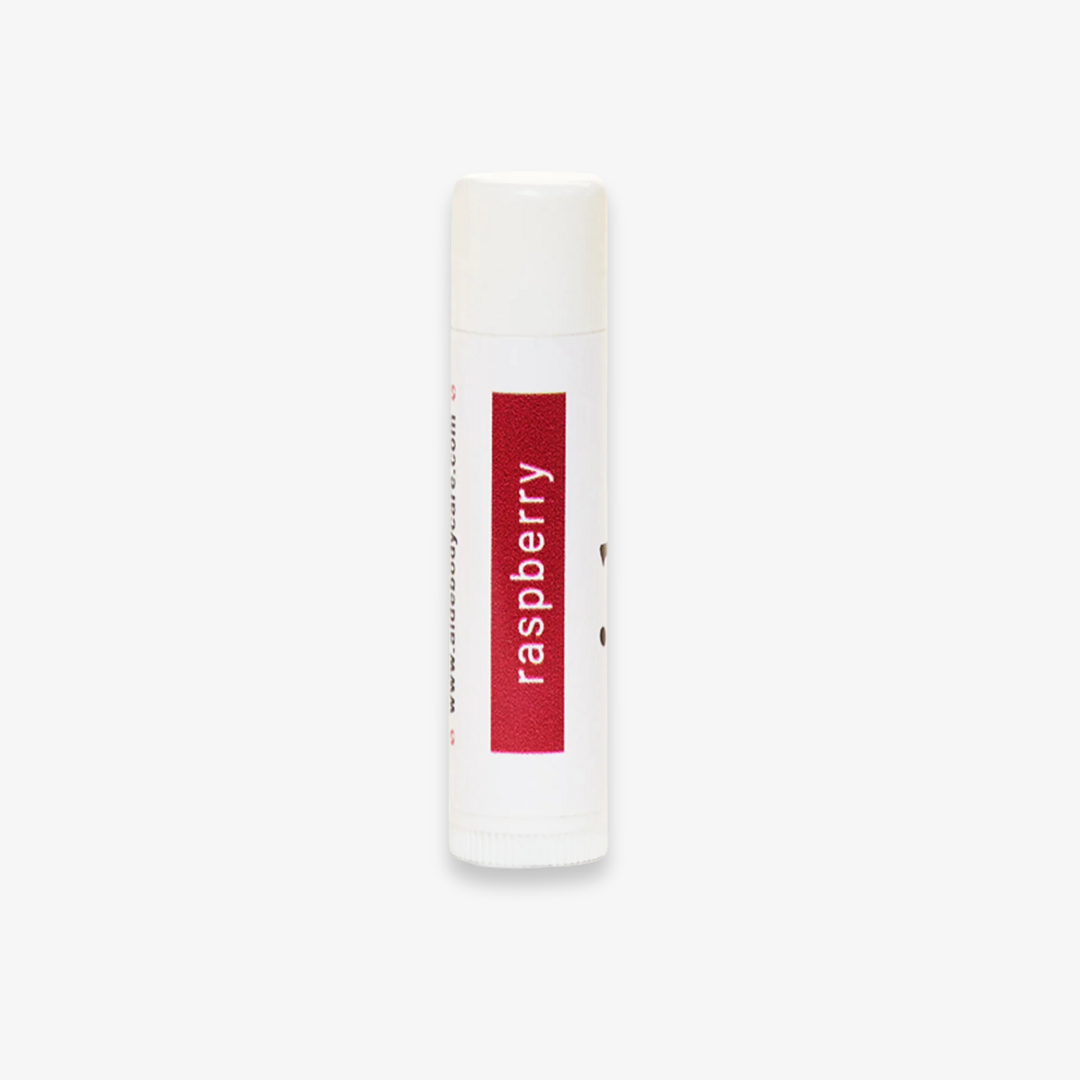 A white tube of lip balm with the word "raspberry" printed in red on the label.