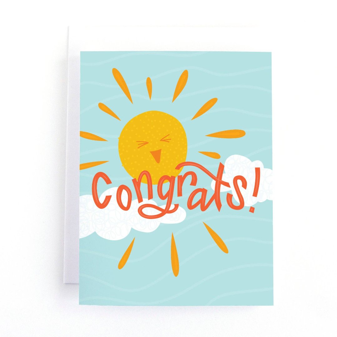 A congratulations card featuring a smiling sun with rays shining on clouds. The text "Congrats!" is written in bold letters below the sun. The card has a light blue background.