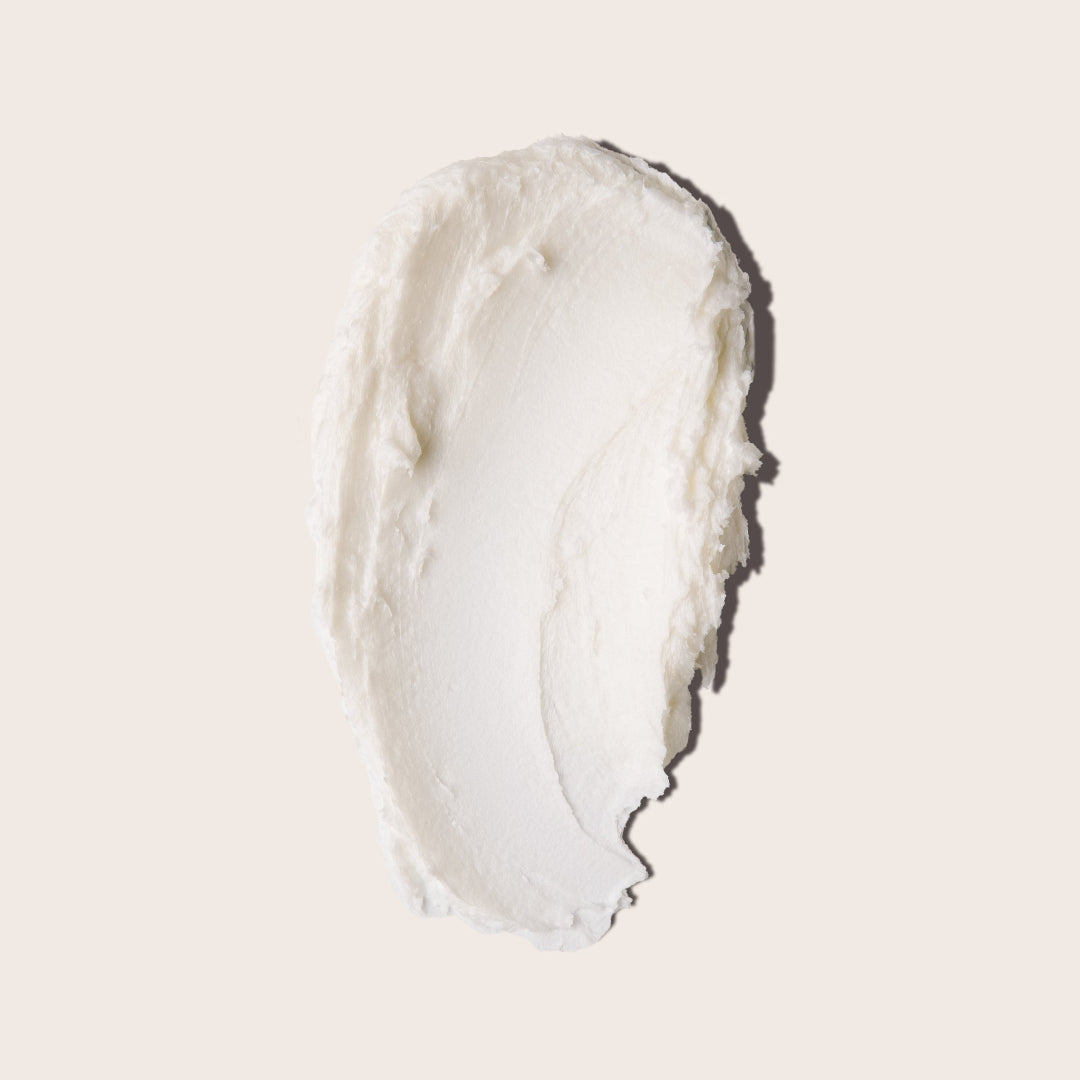 A small, open, silver metal tin of Everist's "The Fragrance-Free Shampoo Concentrate Mini," revealing a white, concentrated product inside. The tin's lid is propped against the base, with text indicating it is dermatologist-developed and contains 20ml of product.