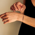 Person wearing a bracelet on a neutral background