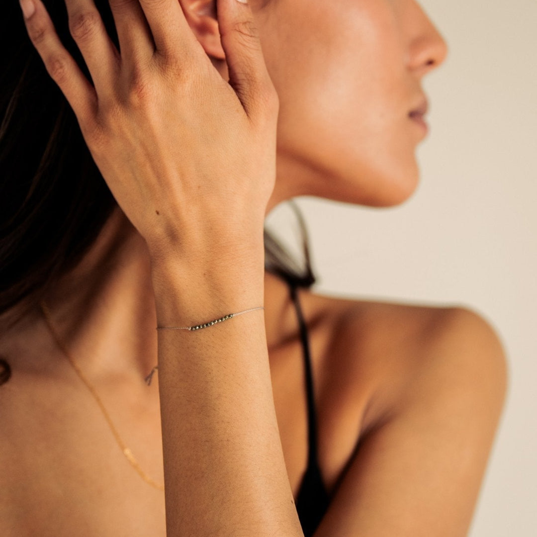 Woman wearing a delicate gold bracelet on her wrist