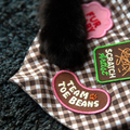 Cat paw on a checkered fabric with embroidered patches