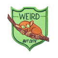Patch with a small creature on a branch and text 'WEIRD BUT CUTE' on a green background