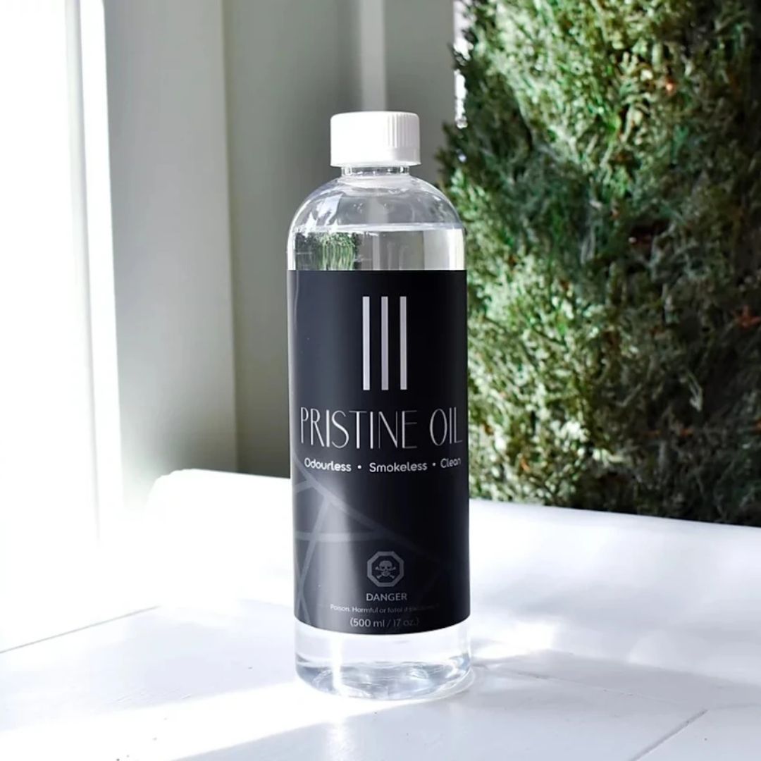 bottle of pristine oil on white surface with tree in background