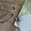 White polishing cloth beside brass hair pin